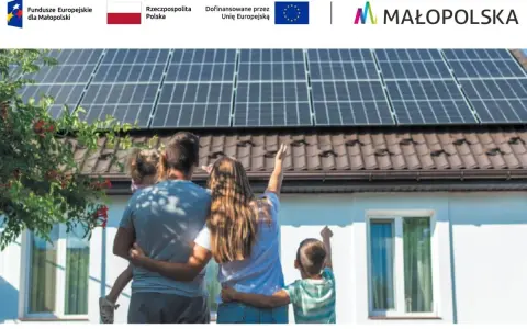 Rodzina podziwia panele słoneczne na dachu, symbolizujące walkę ze stratami ciepła w budynku i dążenie do niezależności energetycznej.