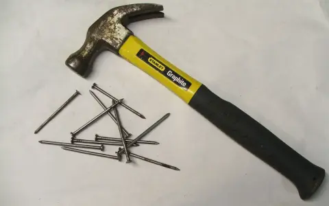 Młotek Stanley Graphite i kilka gwoździ. Różne rodzaje młotków i narzędzi do wbijania gwoździ.