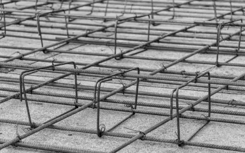 Siatka z prętów zbrojeniowych, gotowa do zalania betonem. Konstrukcja budowlana nabiera kształtu.